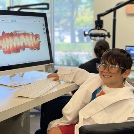 Young child sitting in front of scan of teeth