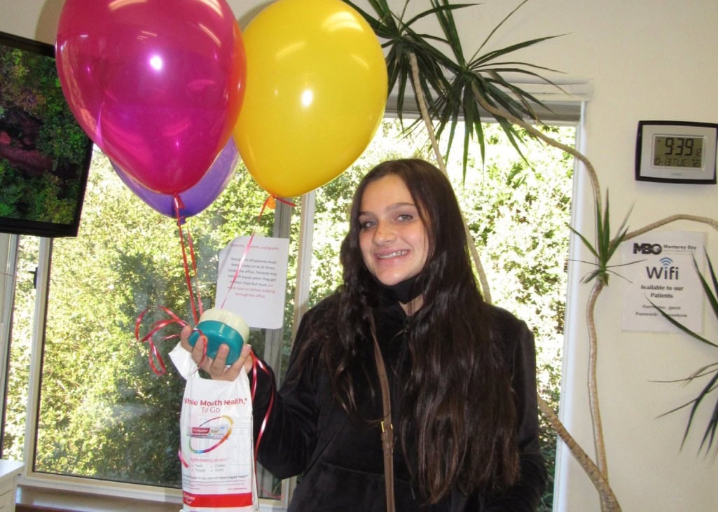Woman holding balloons and smiling